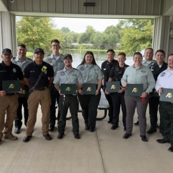 A group of first responders smiles with their Meritorious Service Awards.