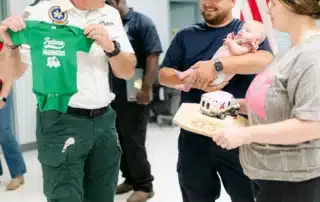 An Acadian Ambulance employee speaks with the family of Stevie Moses.