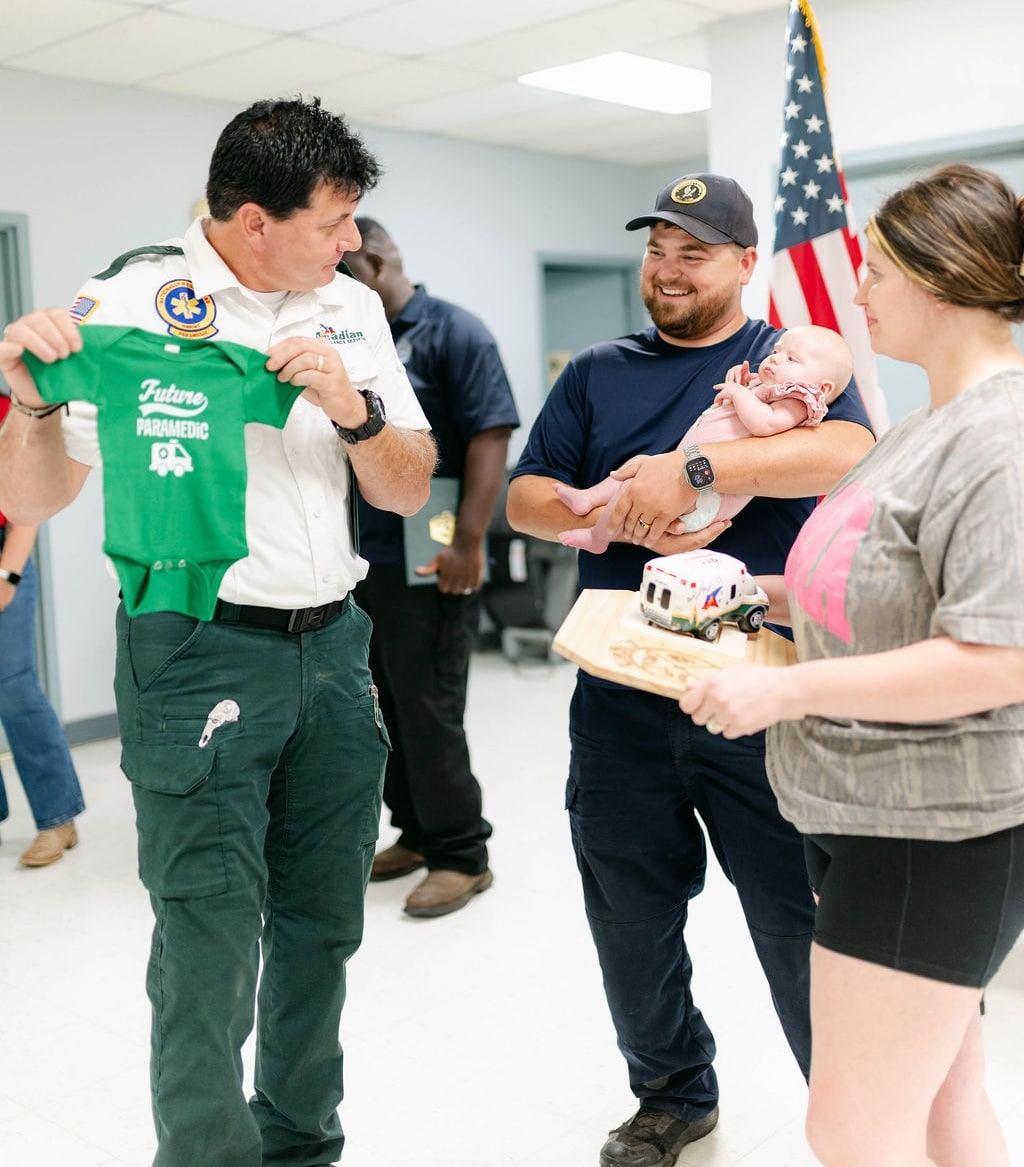 An Acadian Ambulance employee speaks with the family of Stevie Moses.