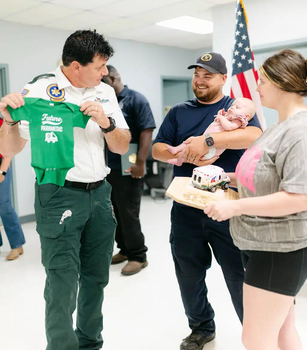 An Acadian Ambulance employee speaks with the family of Stevie Moses.