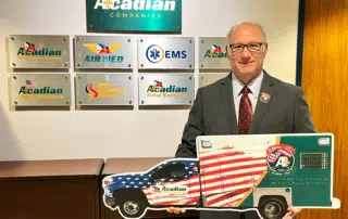 CEO Eddy Dupuis with a cutout of Acadian Ambulance's America 250 unit.