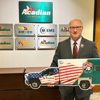 CEO Eddy Dupuis with a cutout of Acadian Ambulance's America 250 unit.