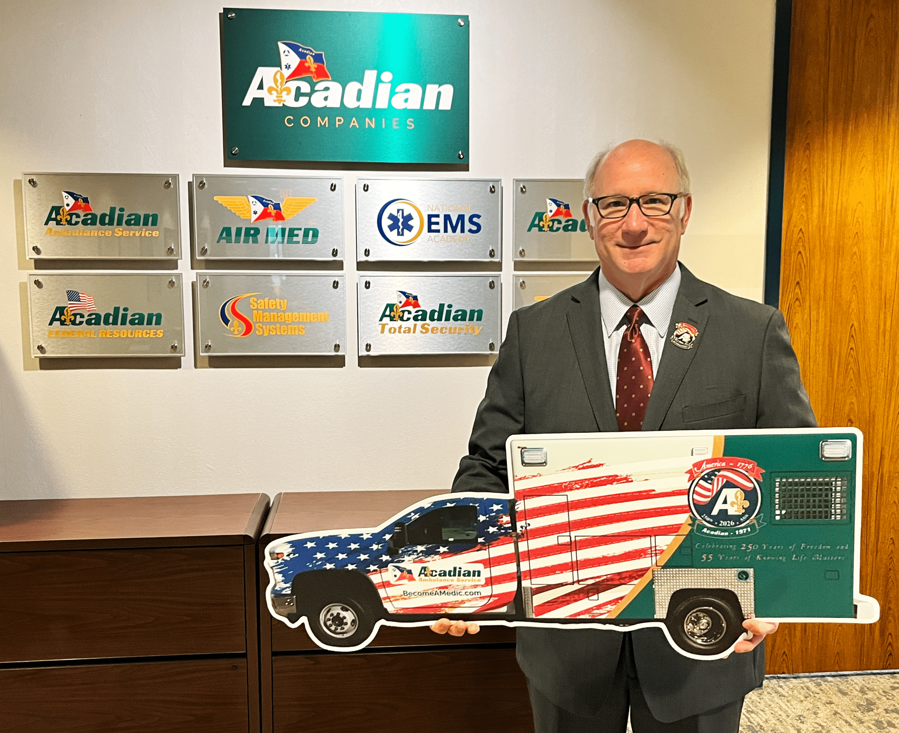 CEO Eddy Dupuis with a cutout of Acadian Ambulance's America 250 unit.