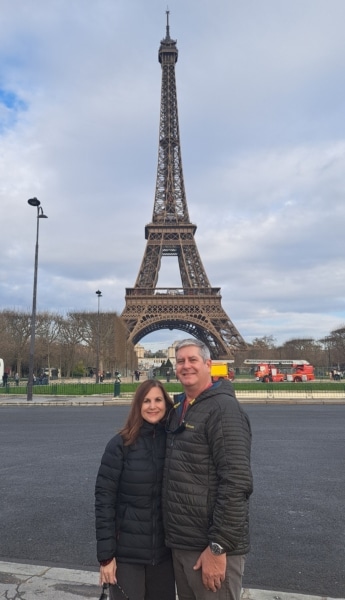 Richard Belle and his wife pose in front of the Eiffel Tower.