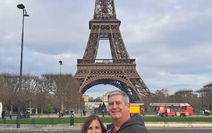 Richard Belle and his wife pose in front of the Eiffel Tower.