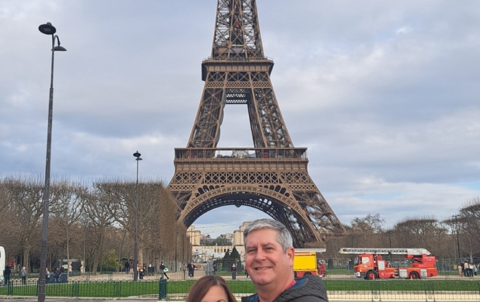 Richard Belle and his wife pose in front of the Eiffel Tower.