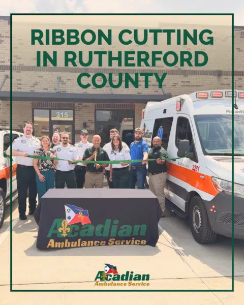 Acadian Ambulance Tennessee team members cut a green ribbon in front of Acadian's new station in Rutherford County.