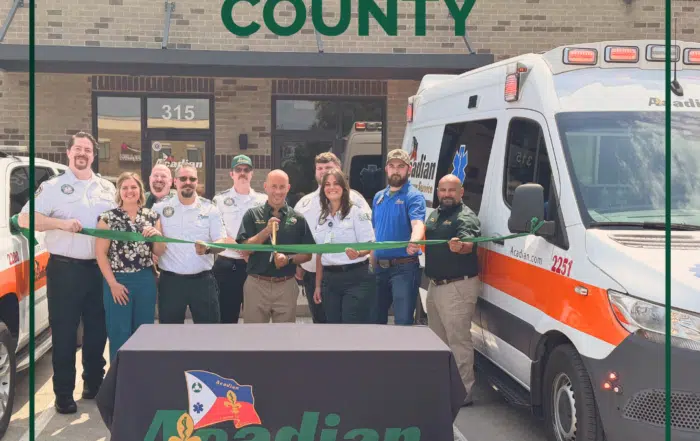 Acadian Ambulance Tennessee team members cut a green ribbon in front of Acadian's new station in Rutherford County.